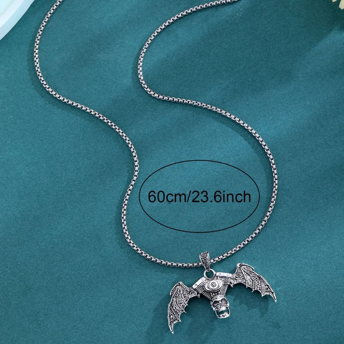 Gothic dark alloy skull pendant necklace with skeleton wing detail on matte black background
