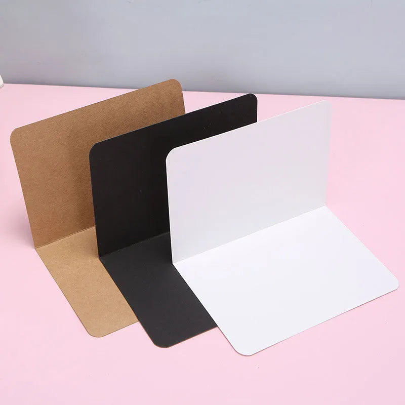 Pack of 100 blank A6 kraft paper folded cards in black, white, and natural brown colours