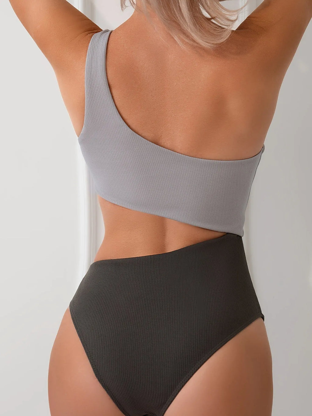 Light grey women's one-shoulder one-piece swimsuit on a model