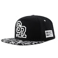 White cotton baseball cap with embroidered lettering on the front, showing the adjustable strap at the back.