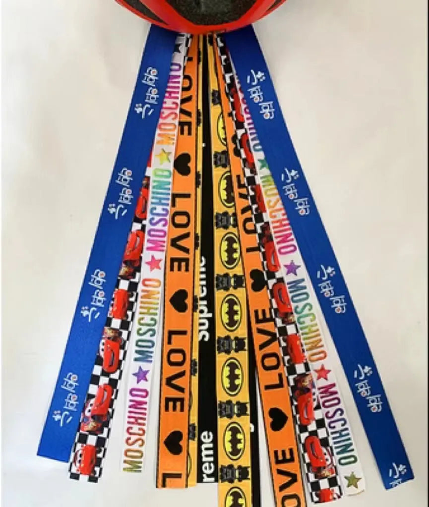 A decorative ribbon streamer for attaching to a child's roller skate or ski helmet, shown in a selection of colours.