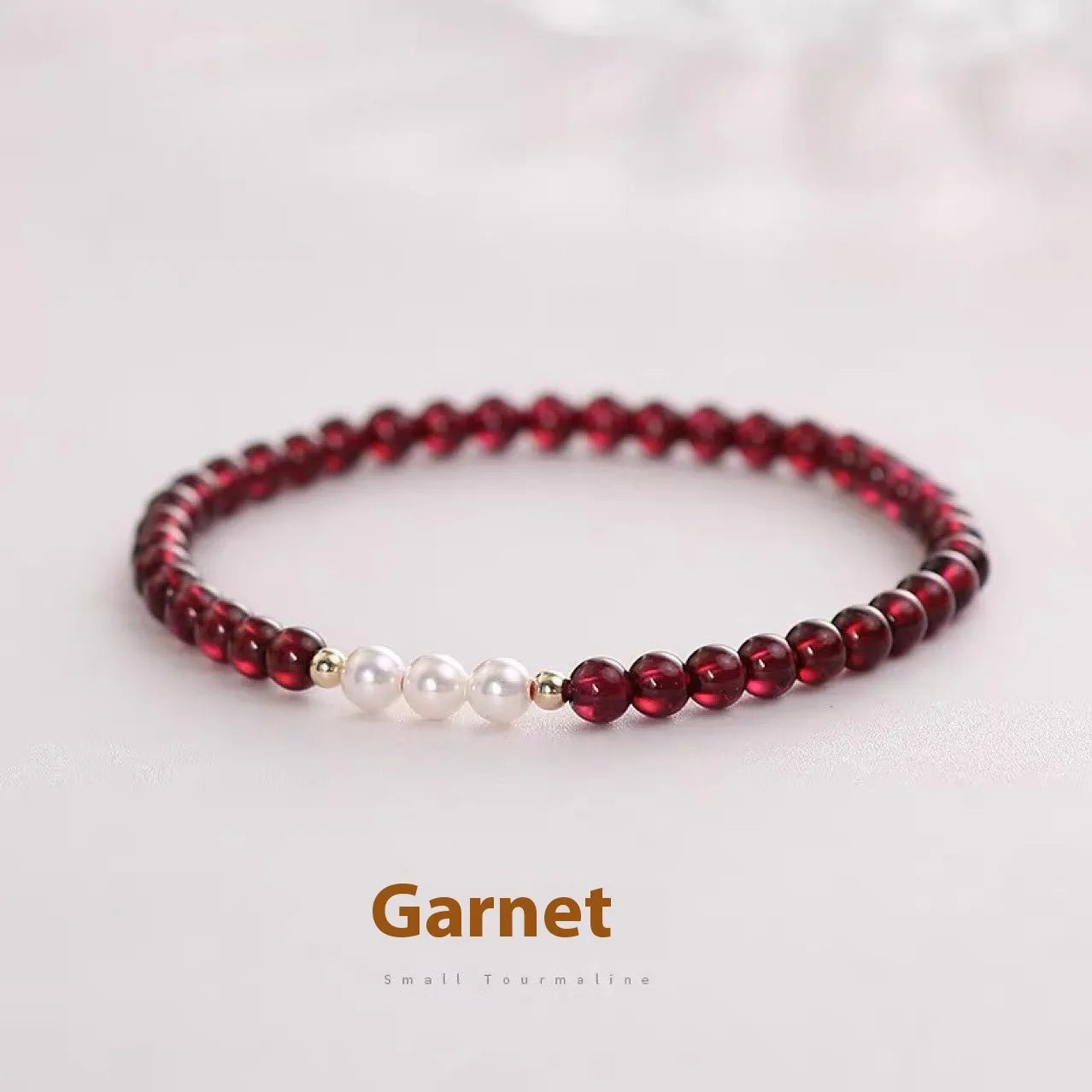 Adjustable women's bracelet with garnet and artificial pearl beads on wrist