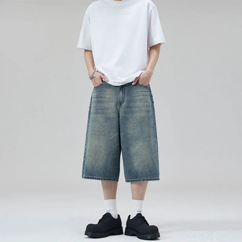 Man wearing light blue straight-leg cropped denim shorts for casual summer wear.