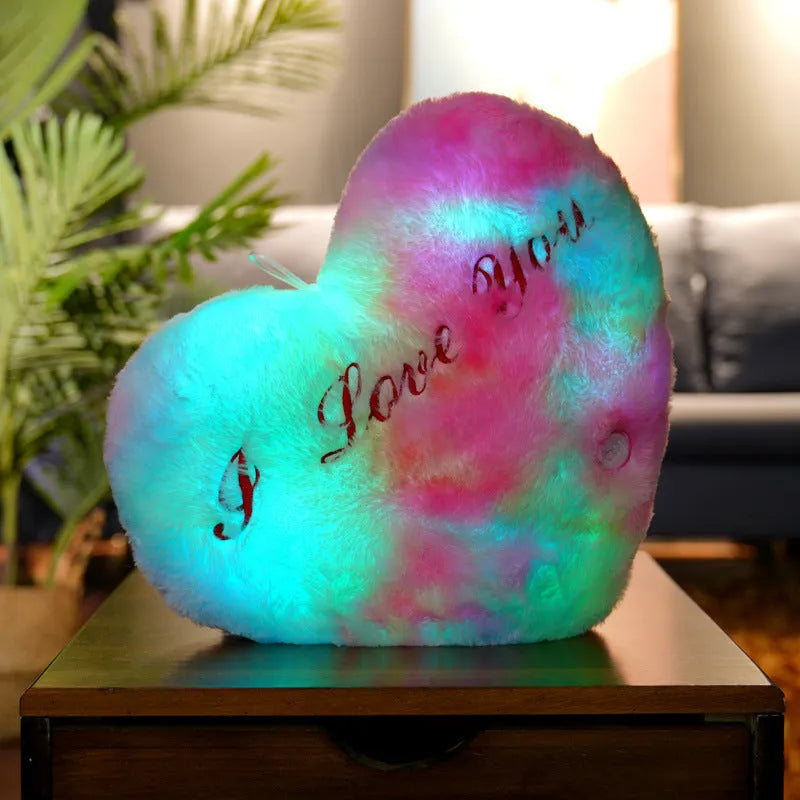 Colourful glowing five-pointed star plush pillow on a dark background, showing soft texture and LED illumination