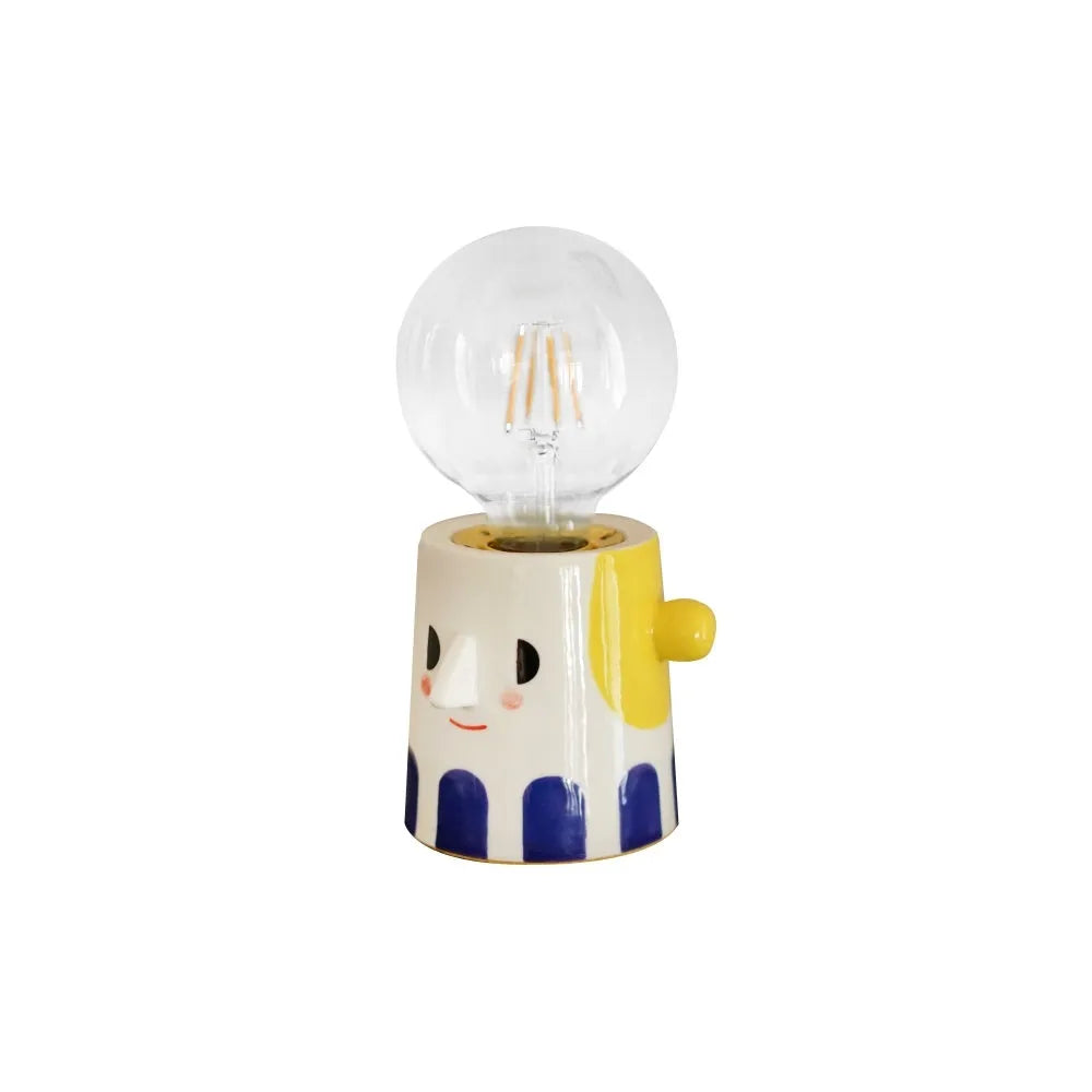 Handmade solid ceramic table lamp with a white spherical headlight shade on a bedside table.