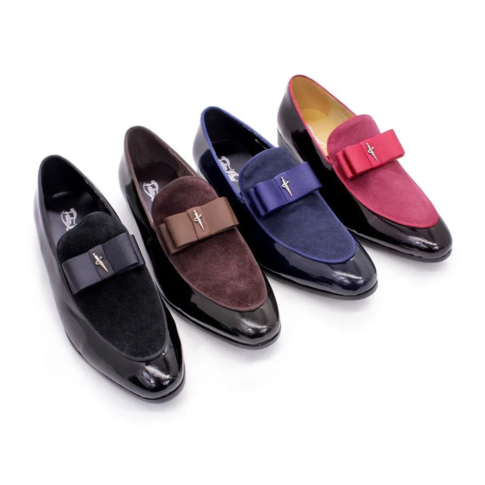 Men's black patent leather tassel loafers with a matte toe, shown on a wooden floor.