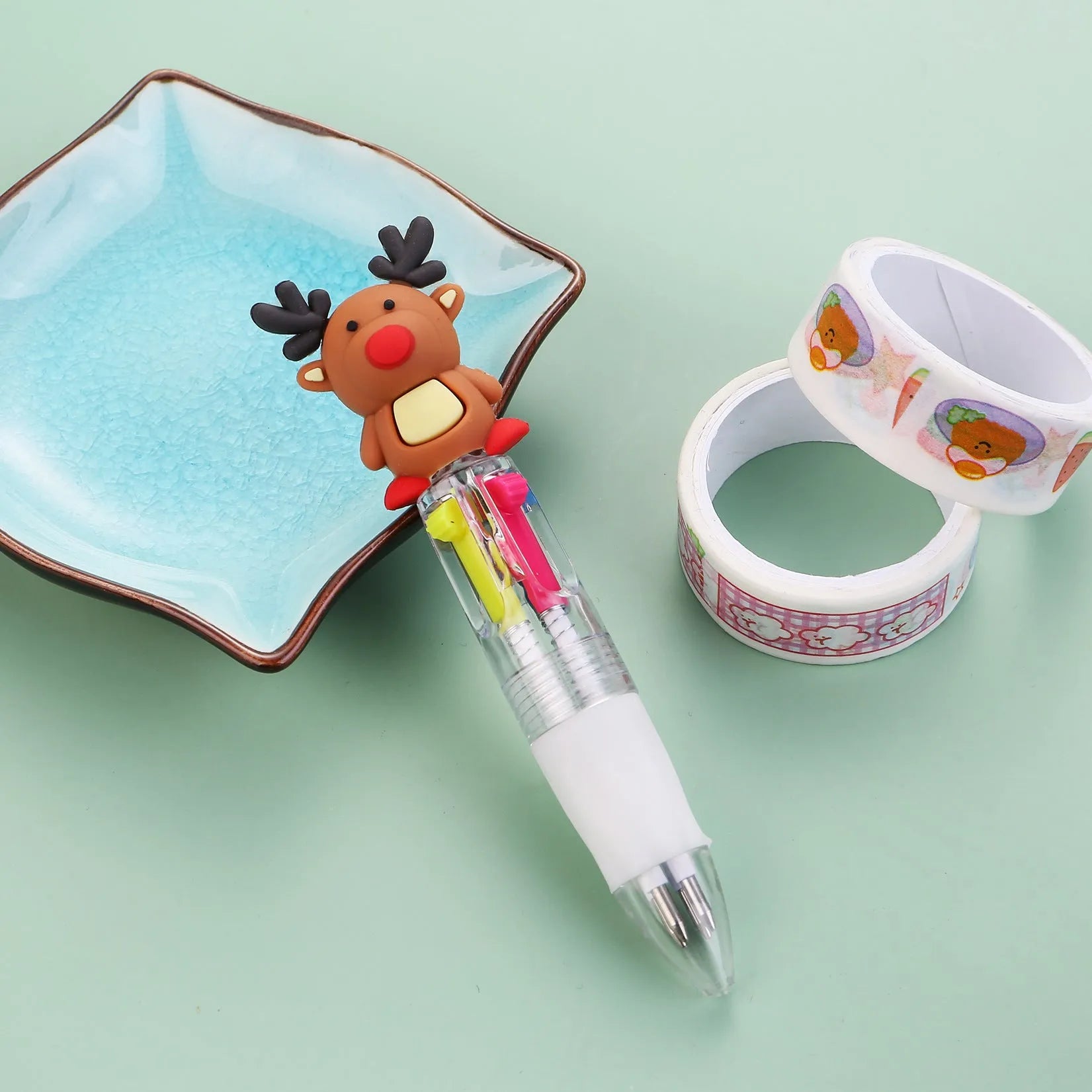 Compact 11cm Christmas ballpoint pen with four colours and festive designs like snowmen and reindeer.