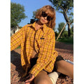 Loose-fit yellow plaid cardigan-style shirt for men and women on a hanger