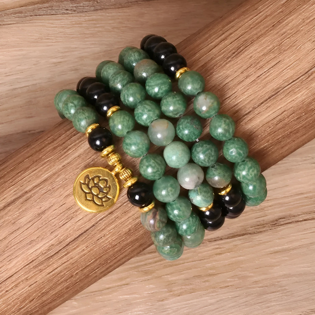 Green and black alloy bead long bracelet with elasticated band on a wrist.
