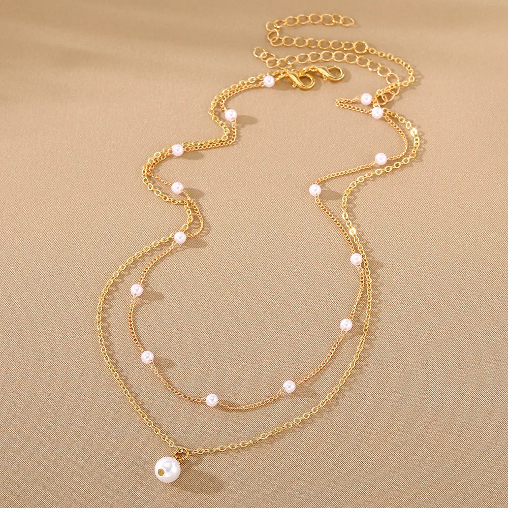Women's gold pearl tassel pendant double-layer necklace set with alloy O-ring chain on display showing three colour variants