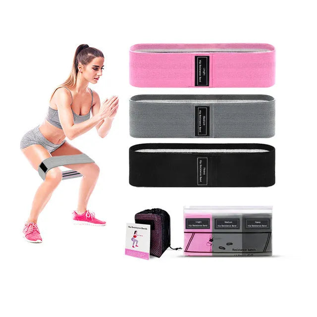 Set of three coloured fabric resistance bands (blue, pink, purple) and a mesh storage bag for fitness training.