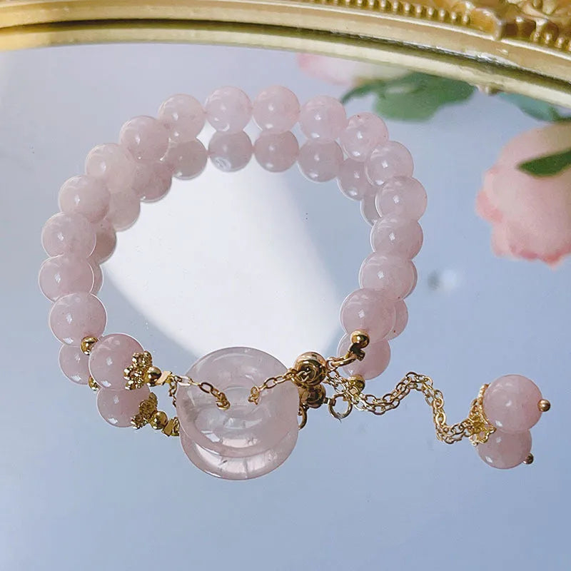 Pink crystal bracelet with peace buckle closure on woman's wrist
