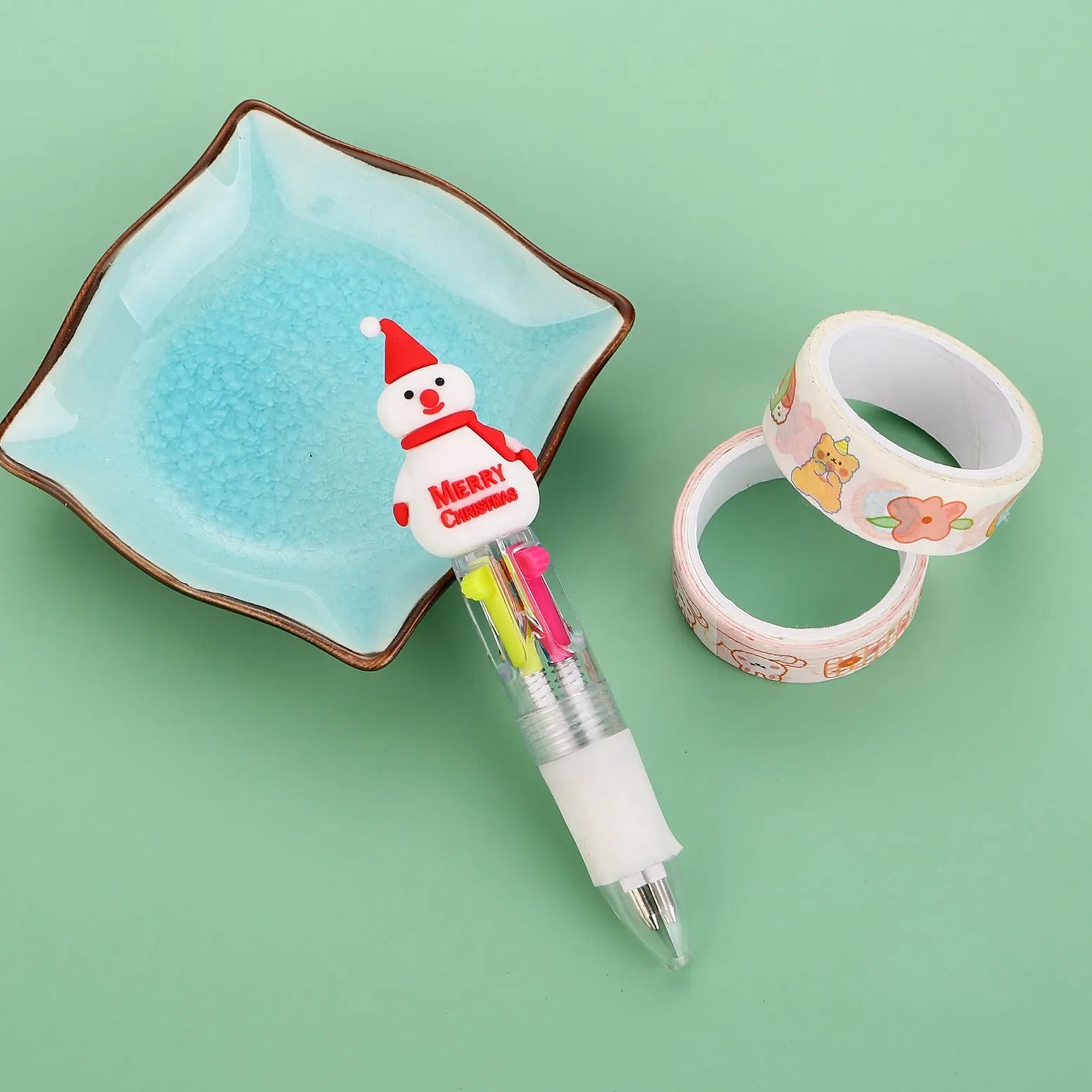 Compact 11cm Christmas ballpoint pen with four colours and festive designs like snowmen and reindeer.