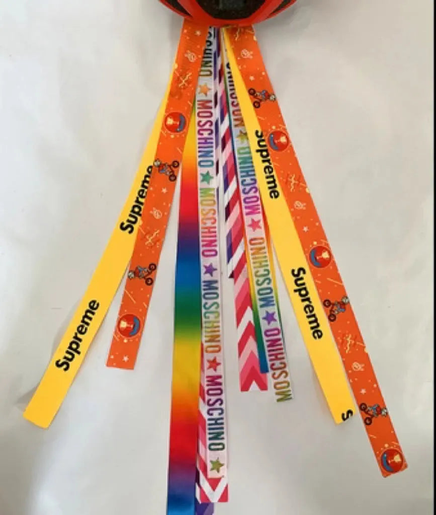 A decorative ribbon streamer for attaching to a child's roller skate or ski helmet, shown in a selection of colours.
