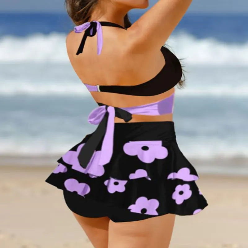 Purple women's bikini set with lace-up detail and matching high-waisted skirt.