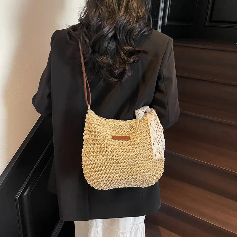Women's straw woven messenger bag with hollowed design in khaki colour, showing vertical square shape and shoulder strap