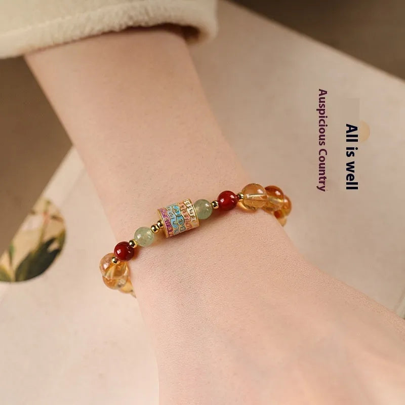 Yellow citrine bracelet with colourful prayer wheel beads on an 8mm round bead strand.