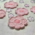 A set of hand-woven decorative wool coasters on a wooden table.