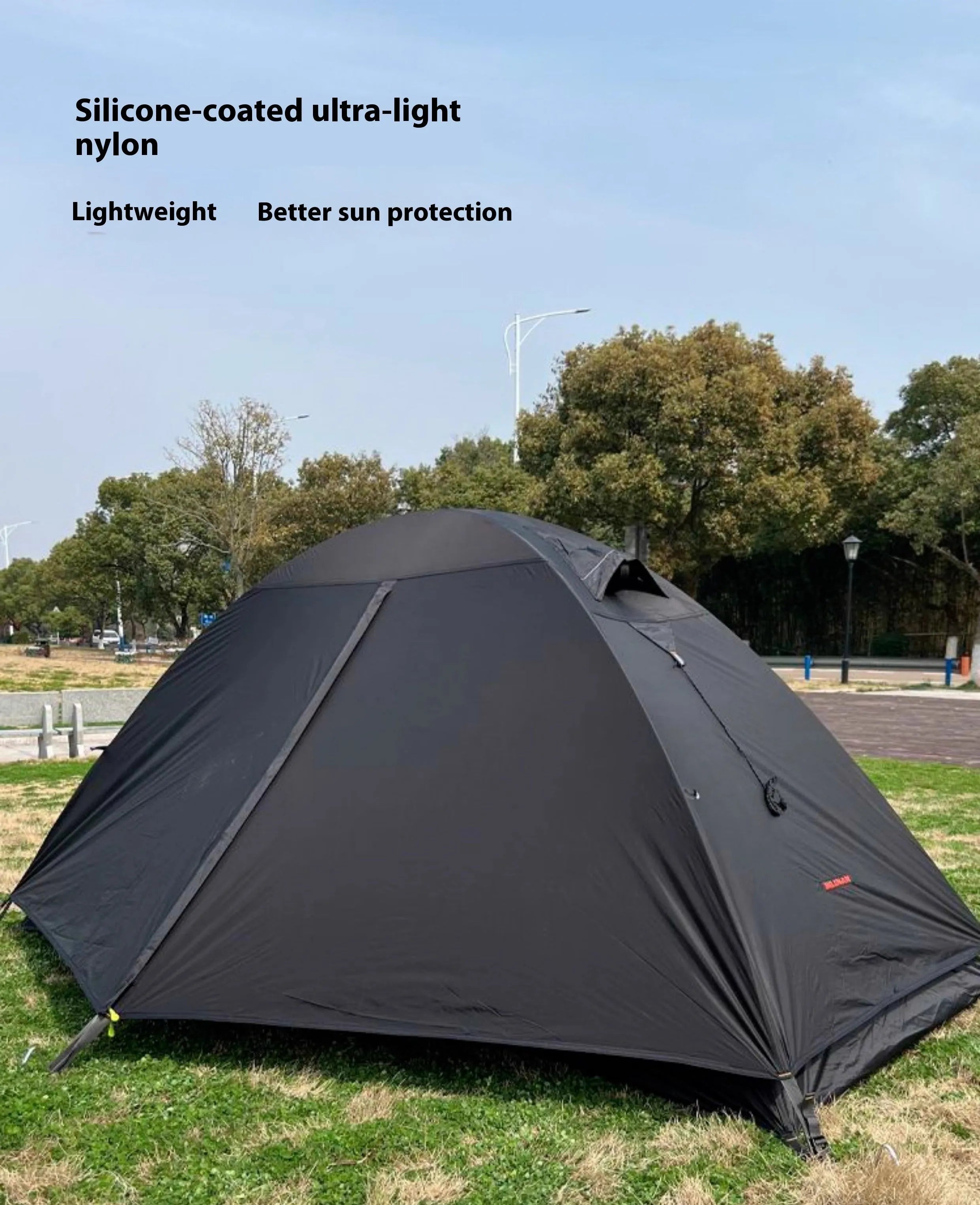 Single-person double-skin hiking tent in orange with aluminium poles, shown pitched in a field.