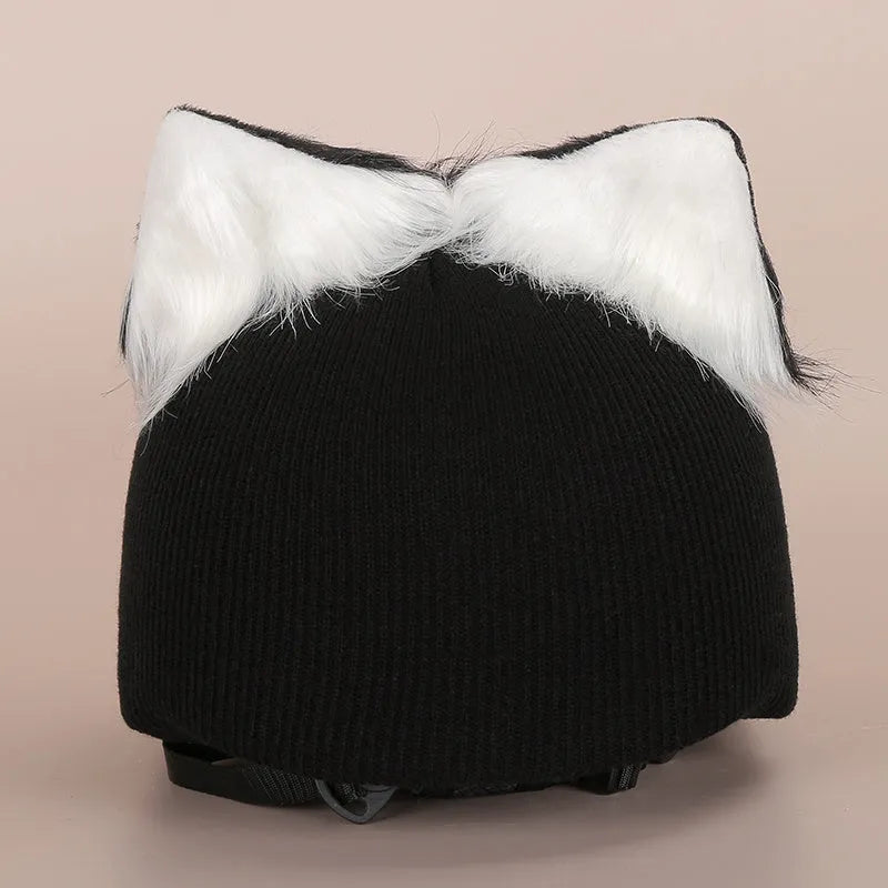 Child wearing a soft plush cartoon animal helmet hat cover with large character face and attached ears.