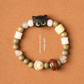Hand-woven adjustable bracelet with bodhi seeds, jade beads, and a cartoon cat's paw guajacwood charm