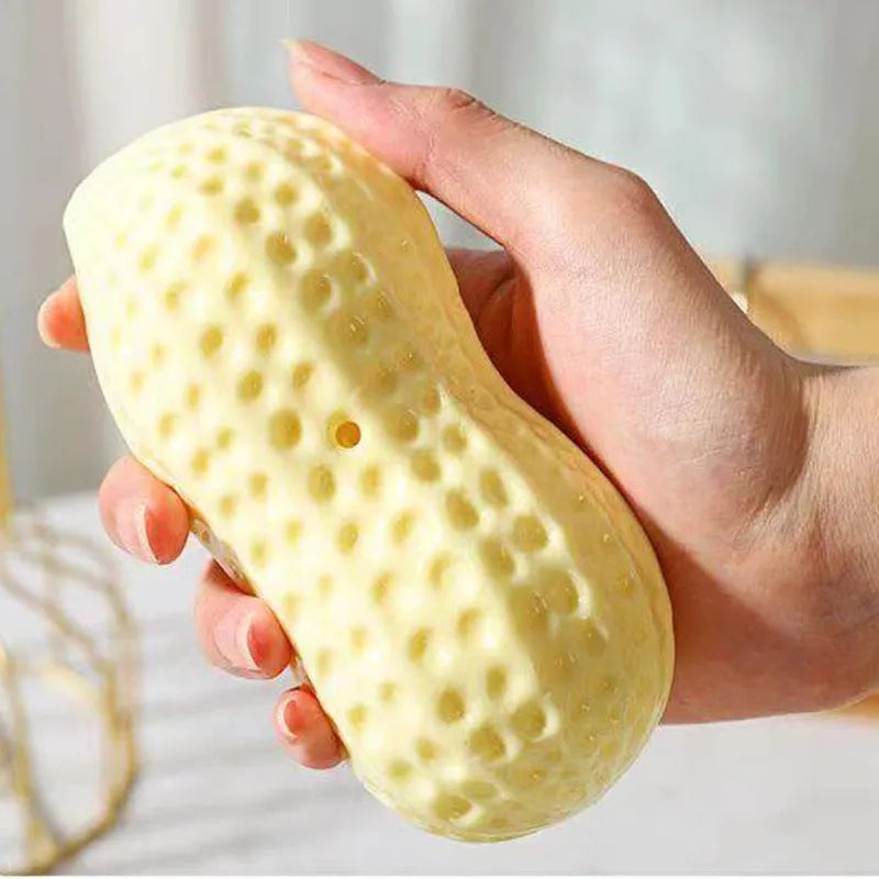 Yellow TPR peanut-shaped dog chew toy with squeaker on a white background