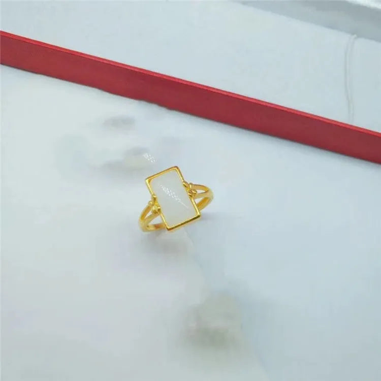 Gold-plated brass ring with an adjustable band and a central green gemstone in a national style.