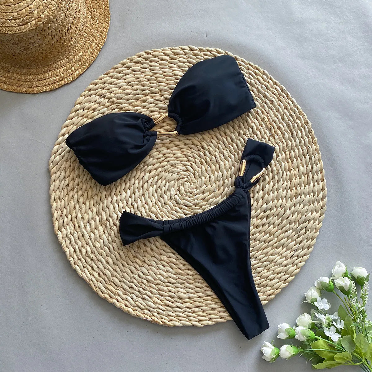 Black solid colour low-waist bikini swimsuit for women on a white background.