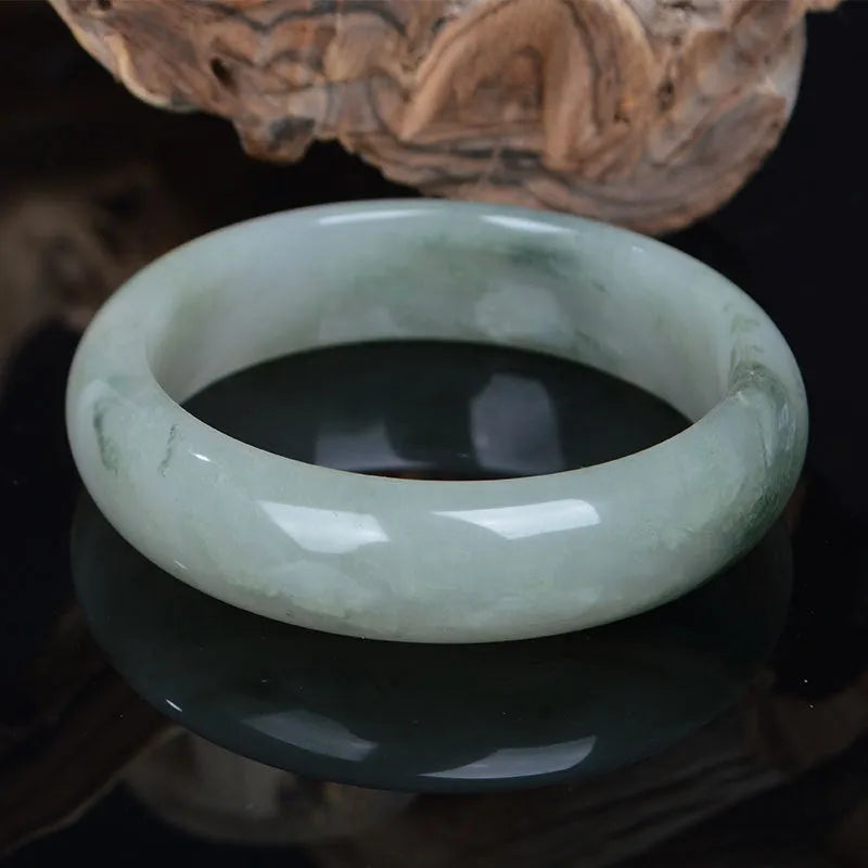 Natural Jinsi Jade Chinese style bracelet in a bangle shape on a plain background.
