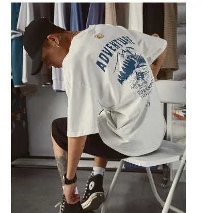 A man wearing a black, loose-fit, short-sleeved polyester blend t-shirt.