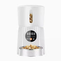 Black and white automatic pet feeder with digital display, food hopper, and USB cable.