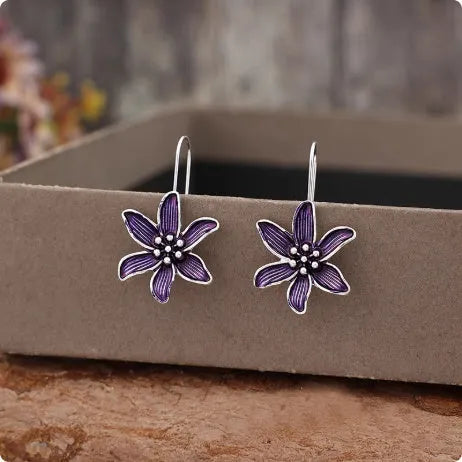 A pair of purple floral alloy earrings with a retro design on a white background.