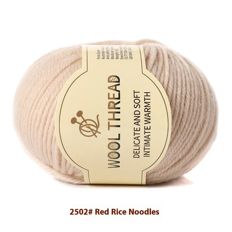One roll of beige domestic wool hand-knitting yarn for size 10 needles next to knitting needles.
