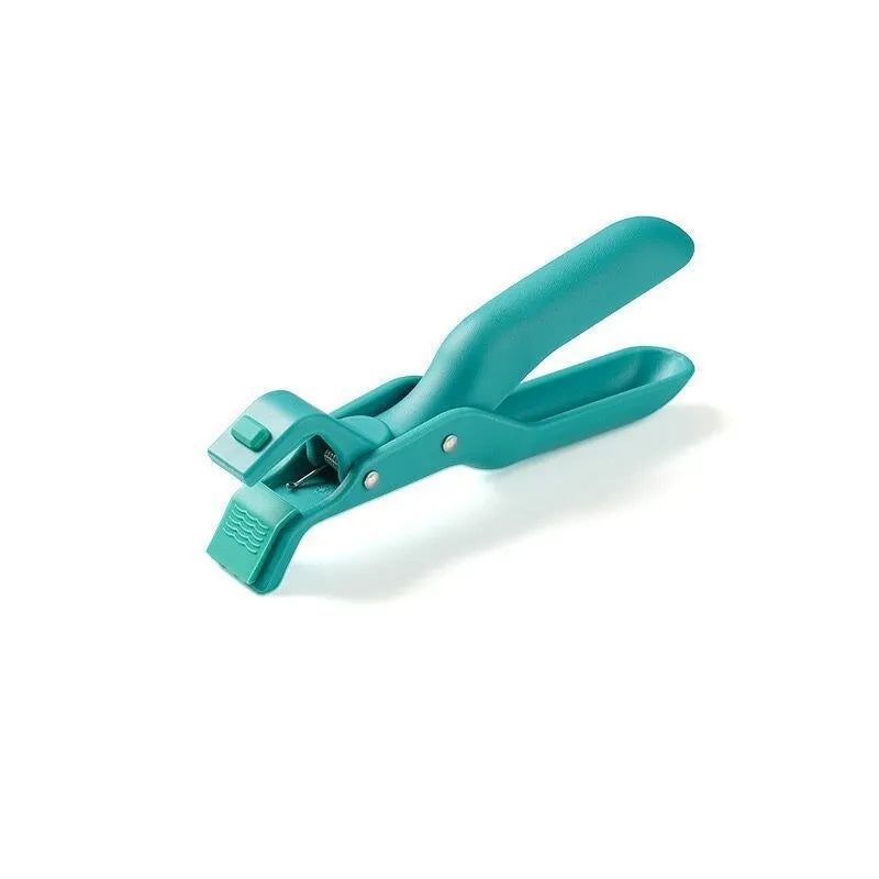 Creative household kitchen silicone anti-scalding clip in carmine colour on a table with a nearby pot