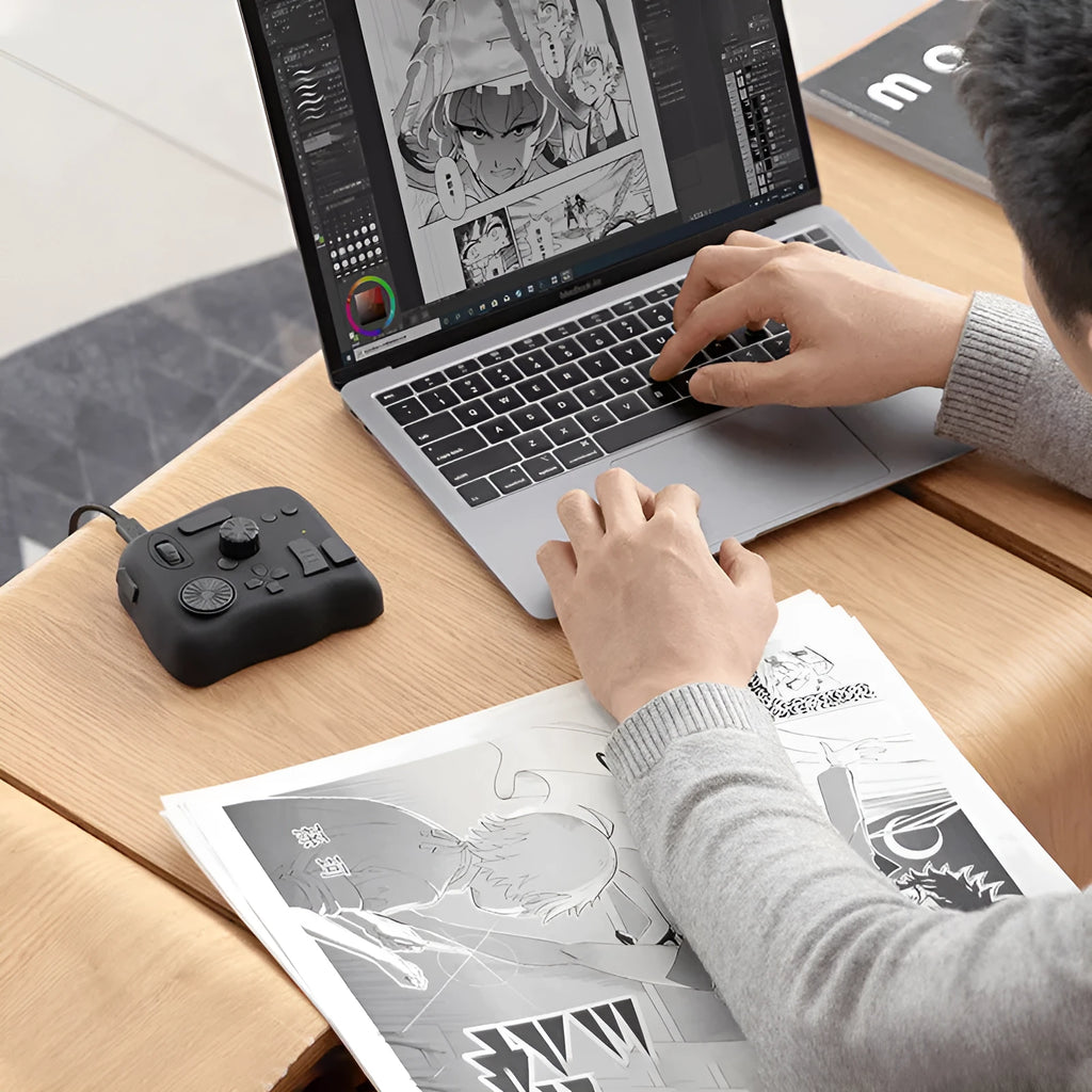 TourBox NEO black video editing controller with dials and buttons on a desk next to a tablet.