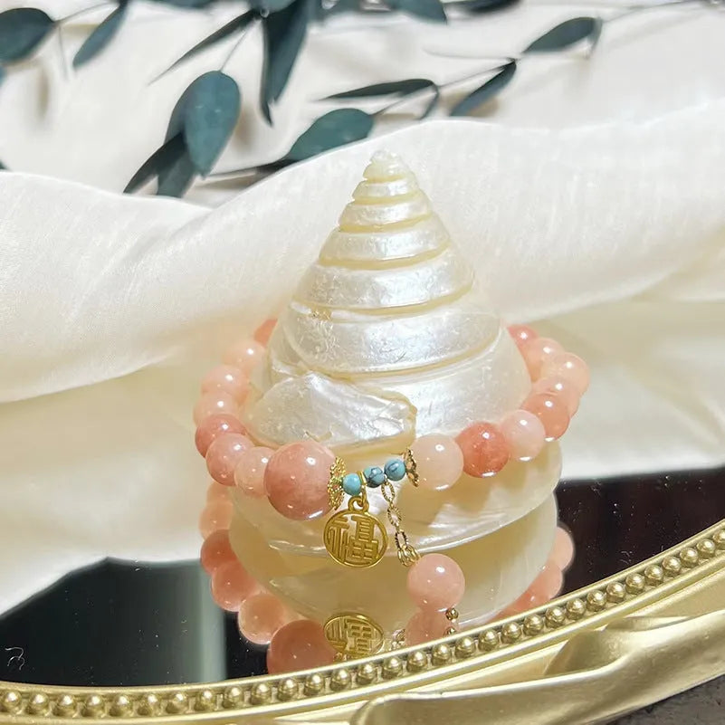 Pink alloy bracelet with natural stone details for women on a simple background.