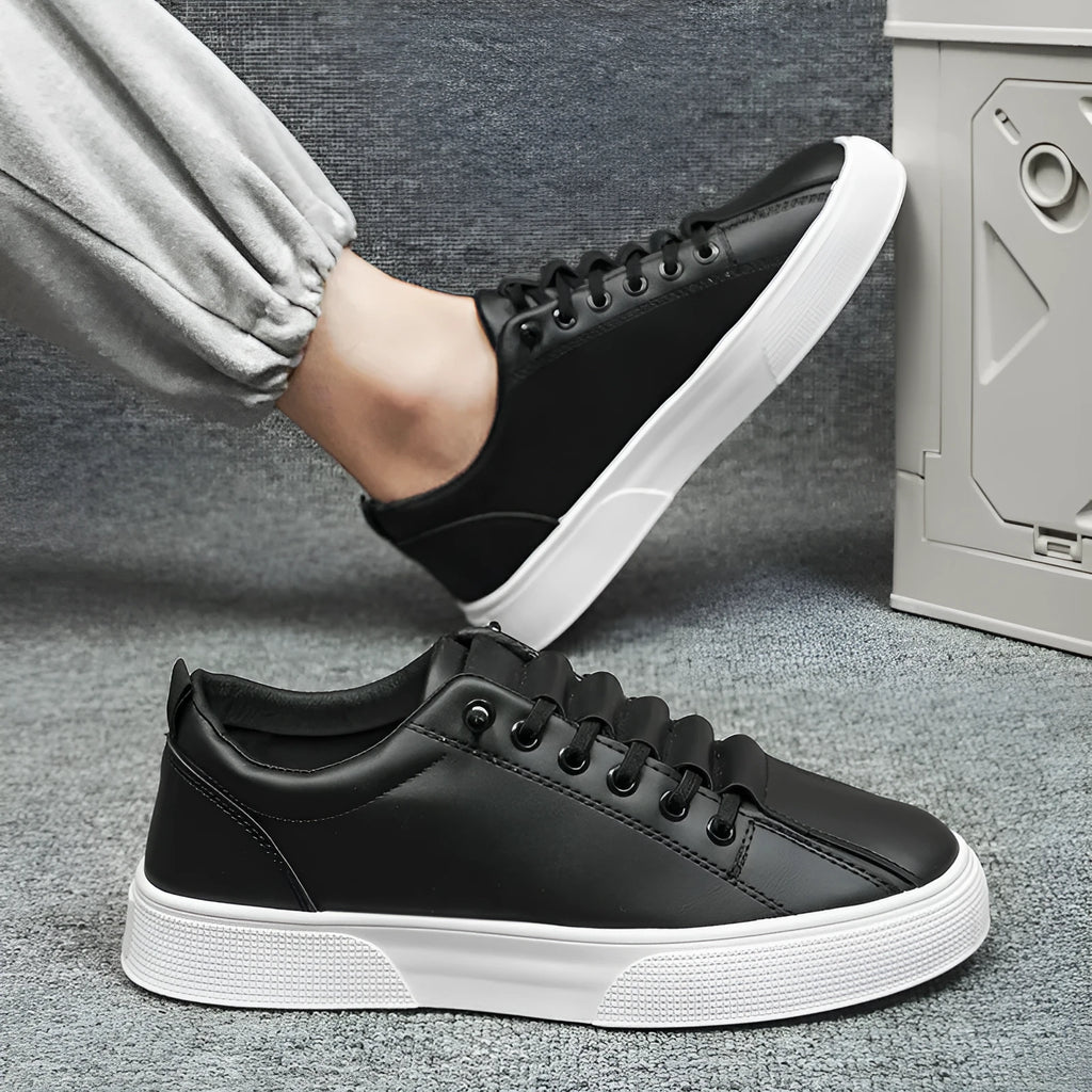 Men's black and white low top sports shoes with mesh panels and synthetic leather upper on a flat PVC sole.