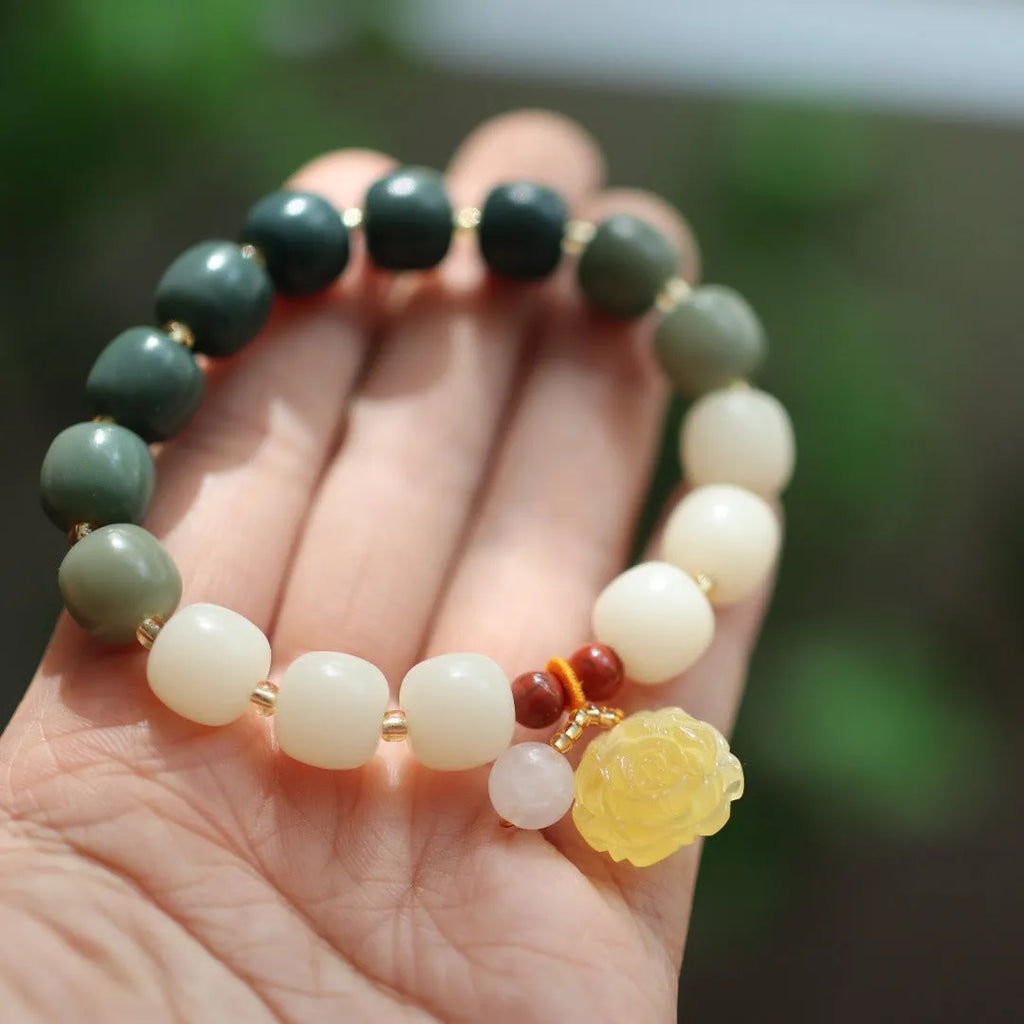 Women's Bodhi root bracelet with gradient white jade beads and a natural beeswax lotus pendant.