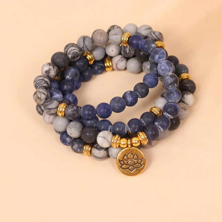 Blue multi-layer bracelet with patterned network stone beads on an alloy base.