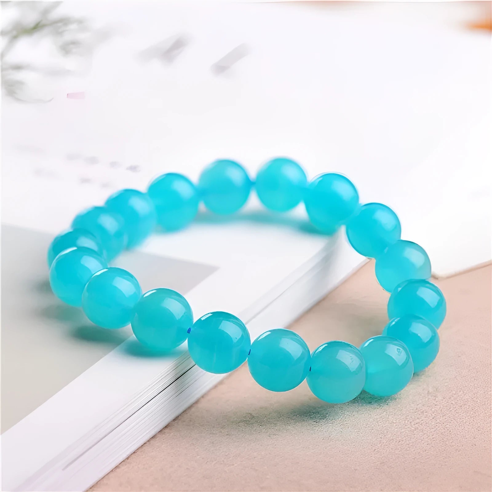 Natural blue-green Grade 7A Amazonite scattered beads in various sizes next to a finished crystal bracelet.