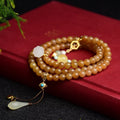 Women's green pine jade and beeswax bracelet with sequin leaves on a 6mm round bead strand.