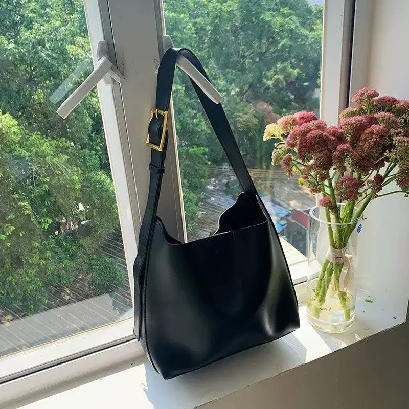 Women's soft PU shoulder bag with tassel detail in black and brown colour options