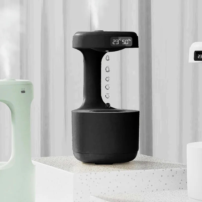 White columnar anti-gravity humidifier with LED clock display and mist output on a wooden desk.