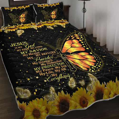 Three-piece black quilt set with butterfly and sunflower pattern, including quilt and two pillow shams, on a bed