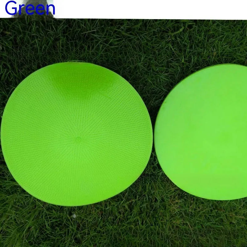 Soft yellow TPE football training target pad flat on grass, 23cm diameter.