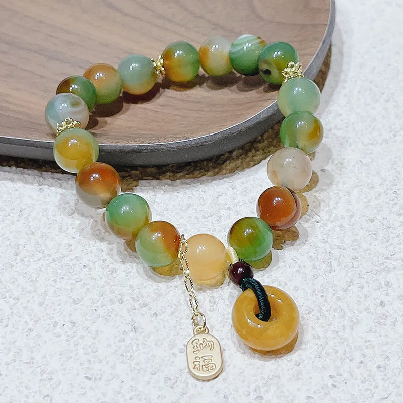 Yellow peacock agate and topaz beaded bracelet with a metal safety chain and peace buckle clasp.