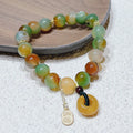 Yellow peacock agate and topaz beaded bracelet with a metal safety chain and peace buckle clasp.