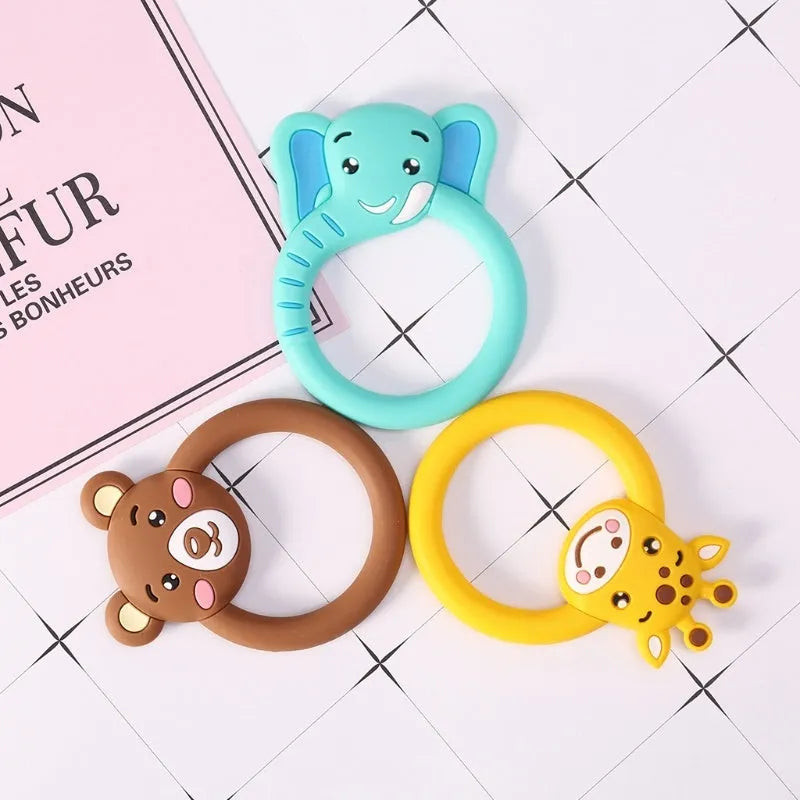 Three silicone baby molar teethers in brown, blue, and yellow on a white background