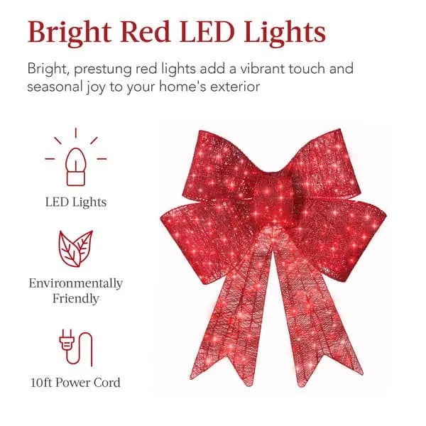 Red satin light up Christmas bowknot on a tree branch with warm glow