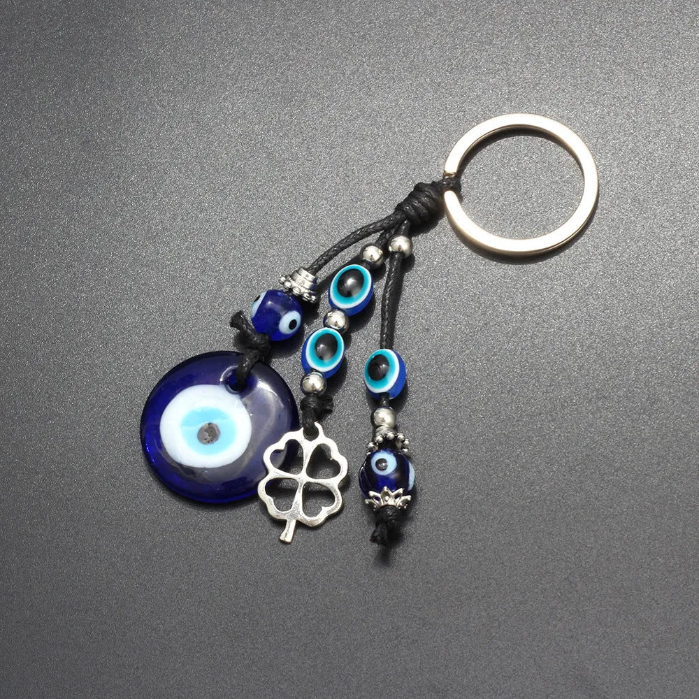 Blue metal eye of evil keychain 4cm pendant with plant-inspired design on grey background